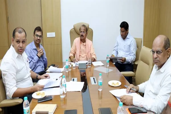 बैठक कक्ष में मेज पर फाइलें और पानी की बोतलें, छह अधिकारी बैठे हैं